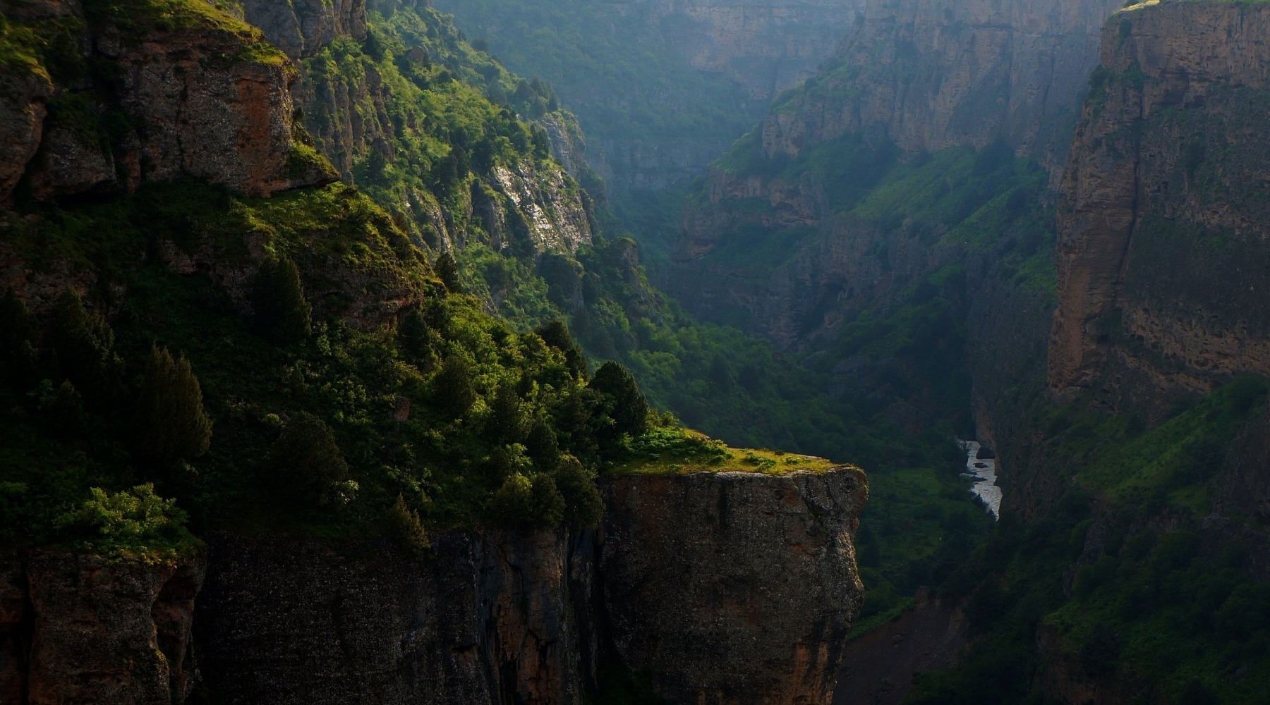 Evening Serenity: A Tranquil River Flowing Through a Rocky Canyon Landscape