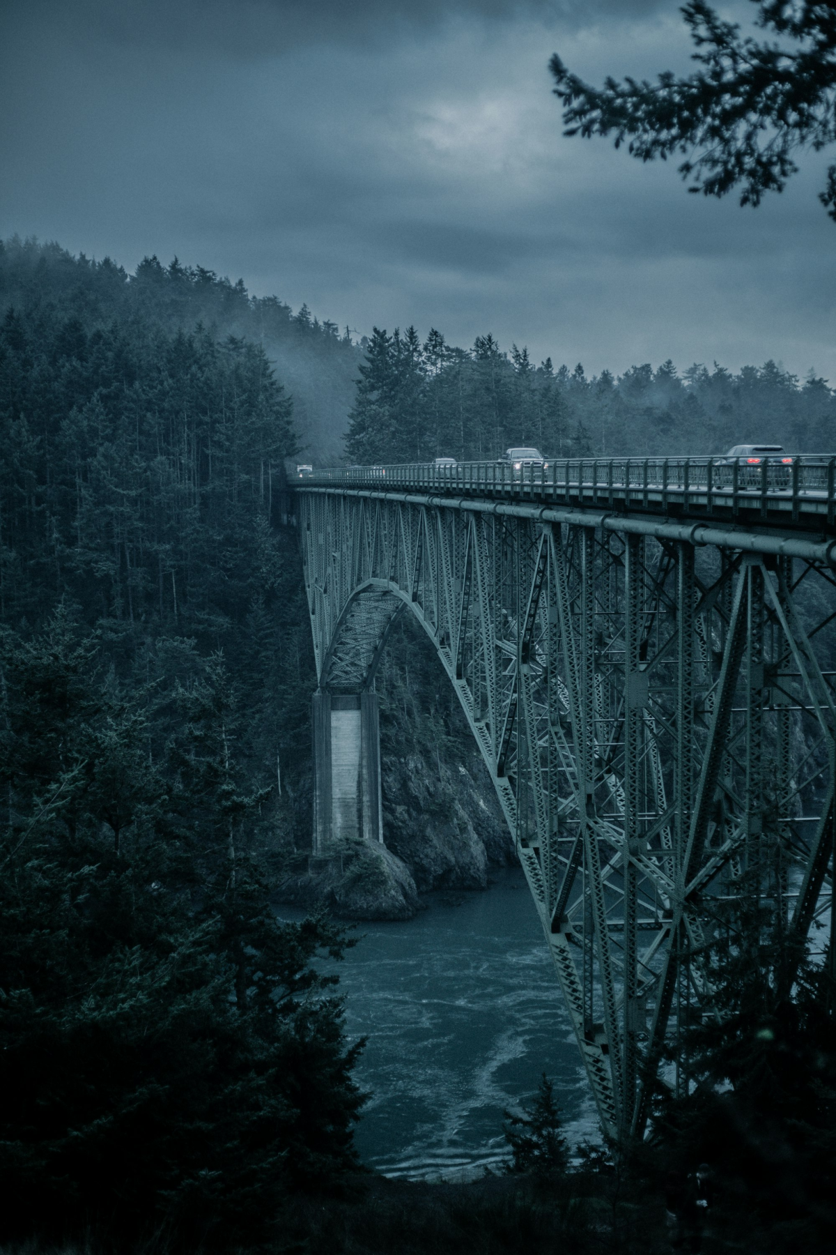 The Majestic Gray Metal Bridge Spanning Across a Tranquil River